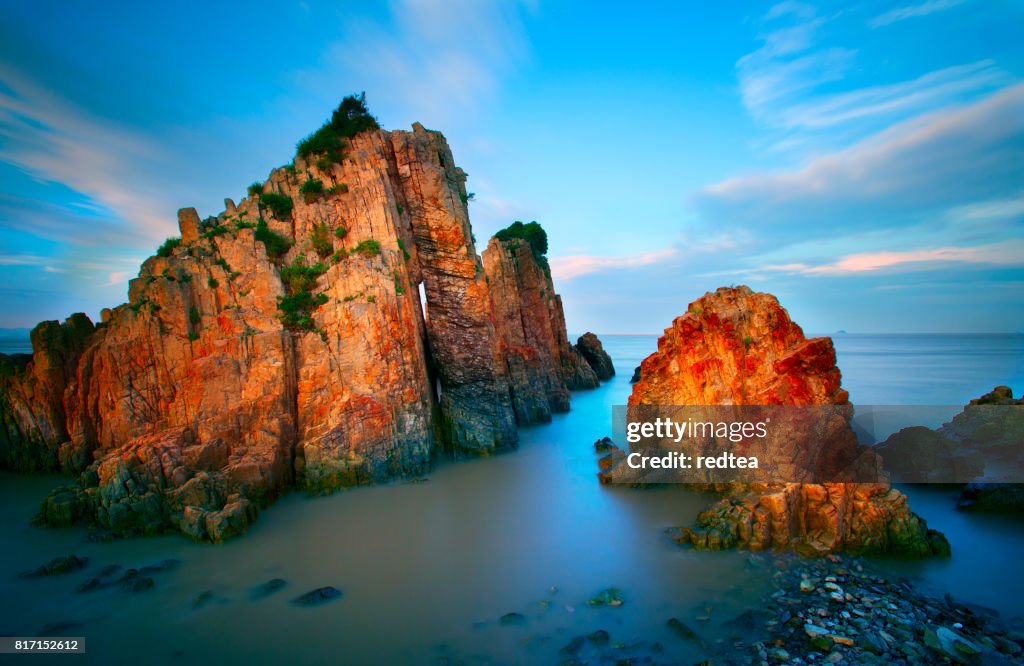 Waves crashing on rocky shore in the sunset