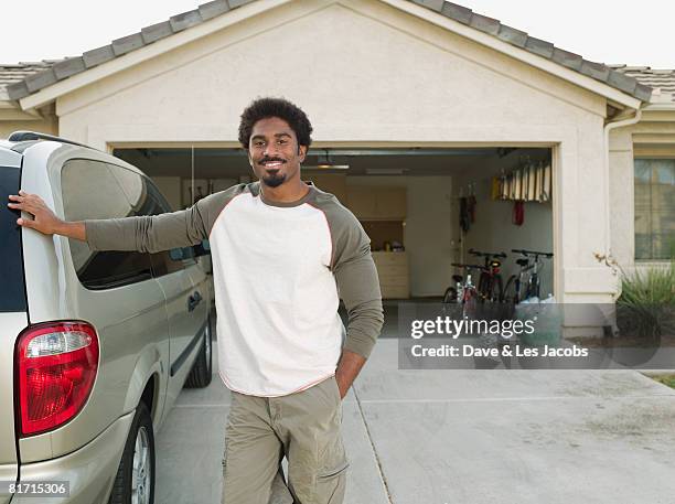 african man leaning on car - car on driveway bildbanksfoton och bilder