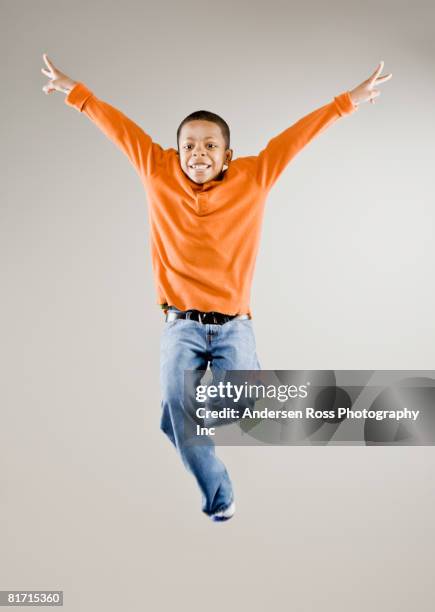 mixed race boy jumping in air - boys jumping stock pictures, royalty-free photos & images