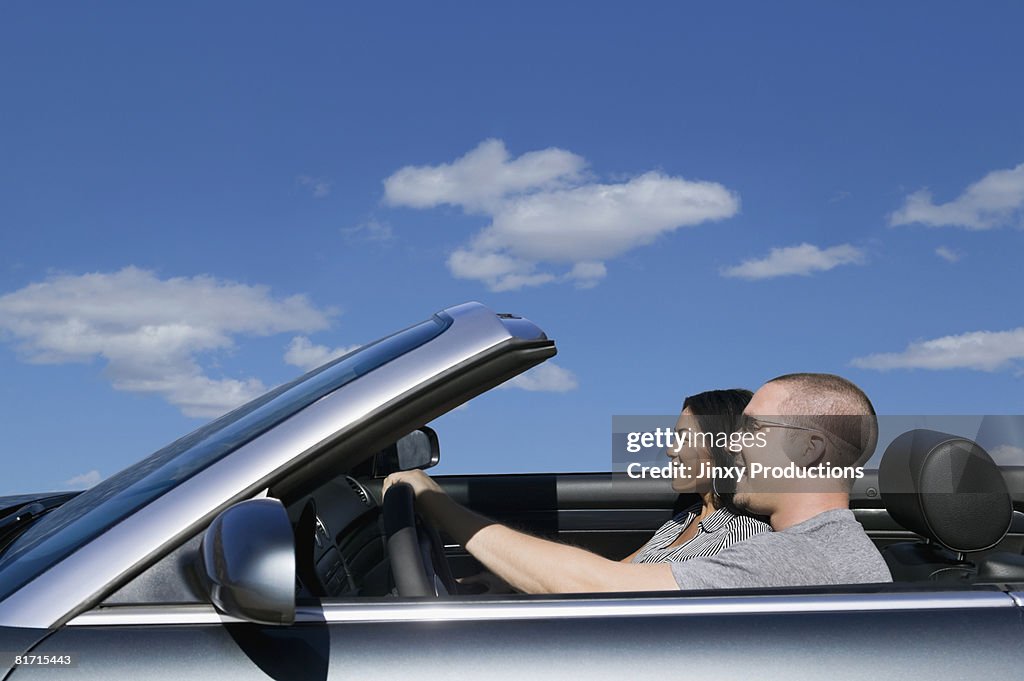 Multi-ethnic couple driving in convertible car