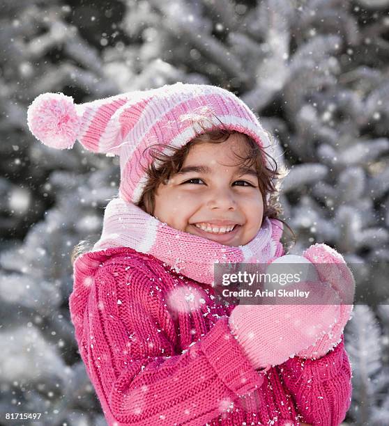 hispanic girl holding snowball - rosa handschuh stock-fotos und bilder