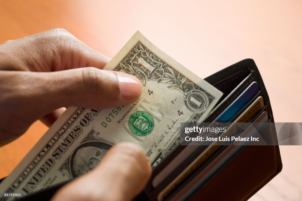 Mixed Race man taking money out of wallet