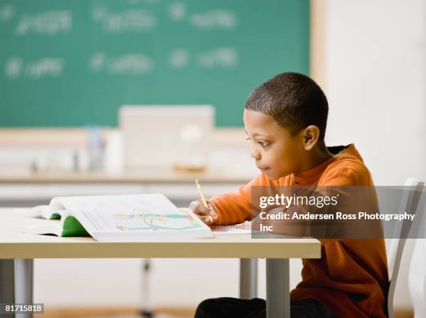 mixed race boy studying - child writing on chalkboard stock pictures, royalty-free photos & images