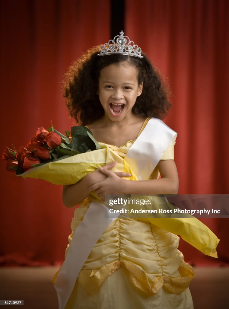 Mixed Race girl dressed as beauty queen