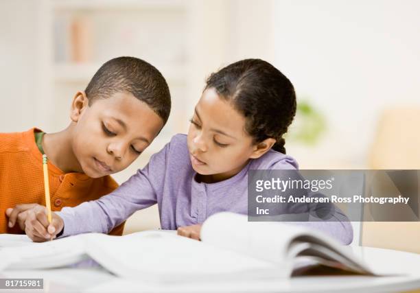 mixed race siblings studying - two young arabic children only indoor portrait stock-fotos und bilder