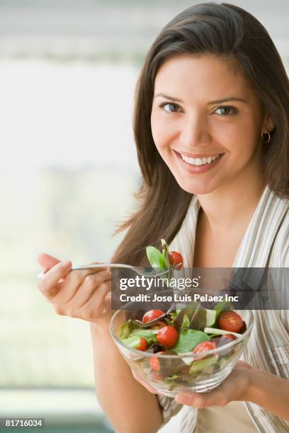 hispanic woman eating salad - woman salad stockfoto's en -beelden