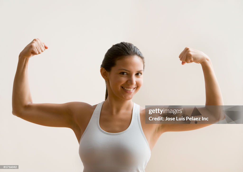 Hispanic woman flexing biceps muscles