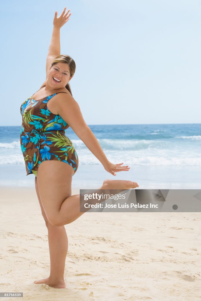 Overweight Hispanic woman posing at beach