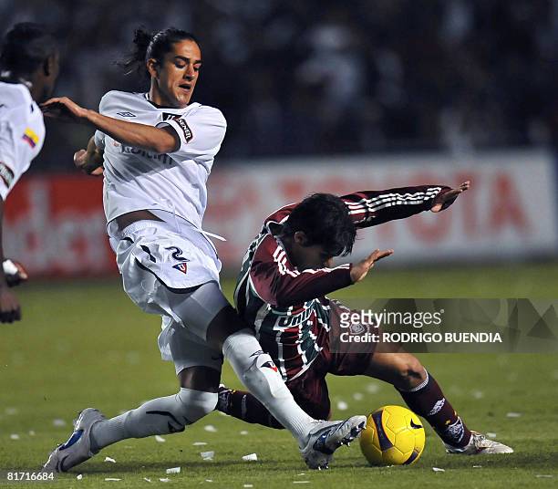 Defender Norberto Araujo of Ecuador's Liga de Quito vies for the ball with midfielder Dario Conca of Brazil's Fluminense, during their Copa...
