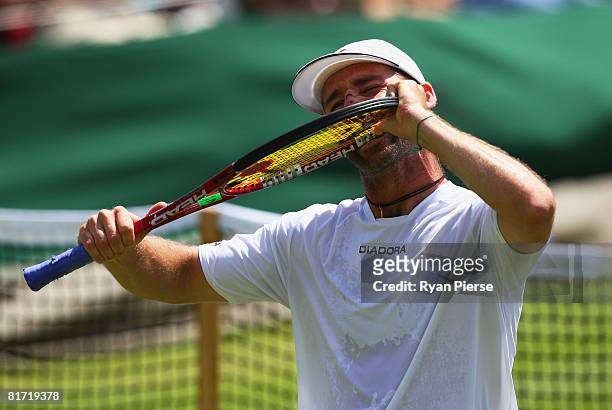 Stefano Galvani of Italy bites his racquet during the round two men's singles match against Mikhail Youzhny of Russia on day four of the Wimbledon...