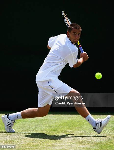 Mikhail Youzhny of Russia plays a backhand during the round two men's singles match against Stefano Galvani of Italy on day four of the Wimbledon...