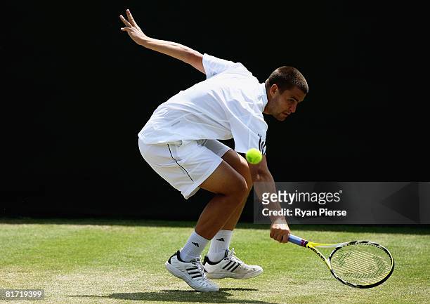 Mikhail Youzhny of Russia plays a backhand during the round two men's singles match against Stefano Galvani of Italy on day four of the Wimbledon...