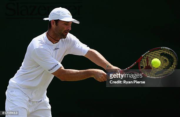 Stefano Galvani of Italy plays a backhand during the round two men's singles match against Mikhail Youzhny of Russia on day four of the Wimbledon...