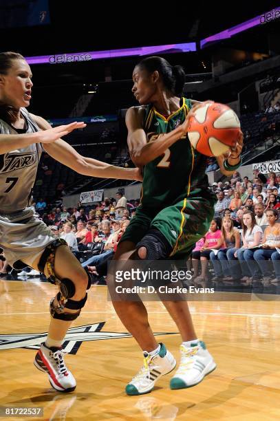 Swin Cash of the Seattle Storm looks to pass the ball under pressure against Erin Buescher of the San Antonio Silver Stars during the WNBA game on...