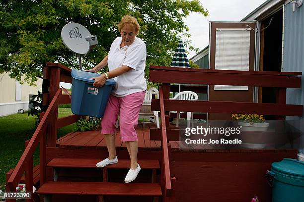 Beverly Lewis carries a box filled with family photographs to her vehicle as she prepares evacuate her home if the waters from the flooding...