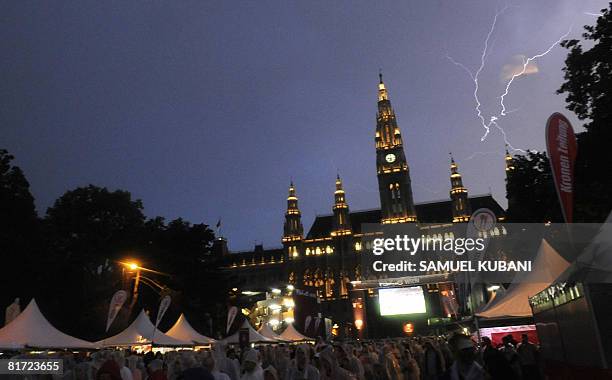 Football fans watch the match in the Vienna fan zone as lightning strikes in front of the Rathaus square during the Euro 2008 semi-final football...