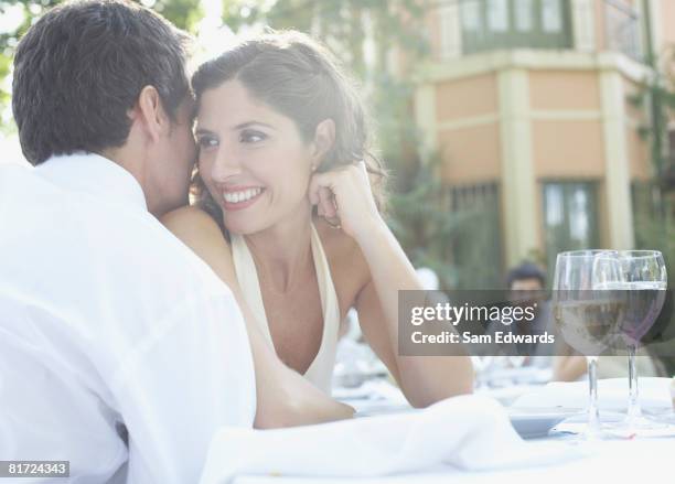 couple at outdoor party whispering and smiling - age contrast stock pictures, royalty-free photos & images