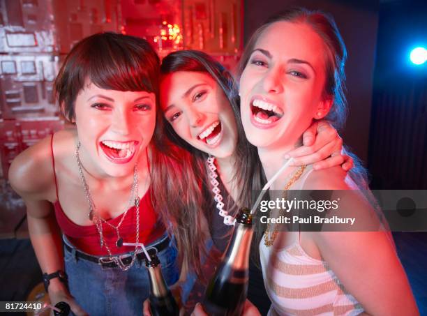 three women in a nightclub drinking and laughing - ladies night stock pictures, royalty-free photos & images