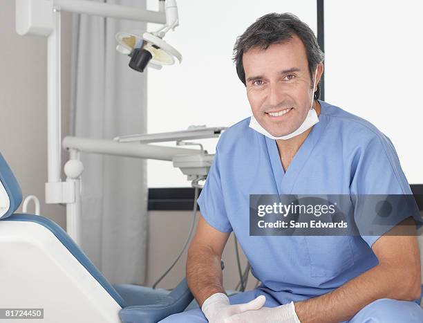 dentist sitting in examination room smiling - dental office front stock pictures, royalty-free photos & images