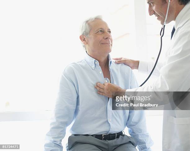 médecin avec stéthoscope sur souriant patient - adult patient with doctor and stethoscope photos et images de collection