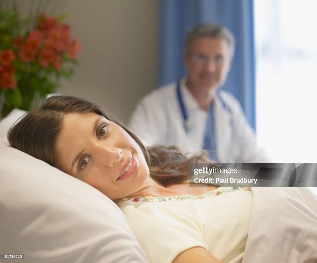 Woman lying in hospital bed smiling