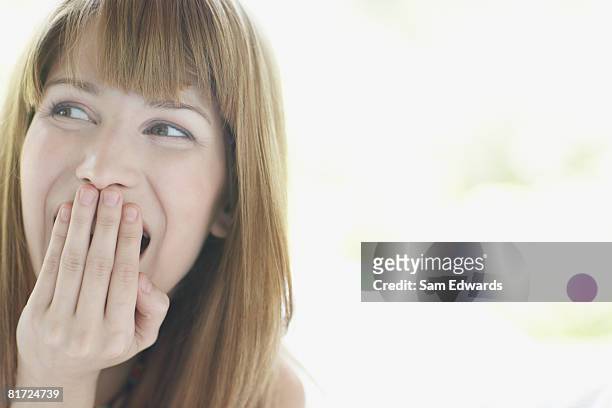 mulher sentada ao ar livre com a mão para a boca rir - mão na boca imagens e fotografias de stock