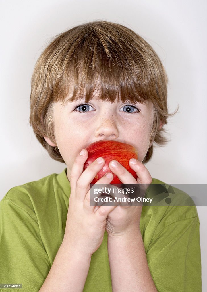 Young boy eating apple