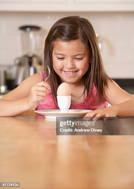 young girl in kitchen with a boiled egg smiling - kid boiled egg bildbanksfoton och bilder