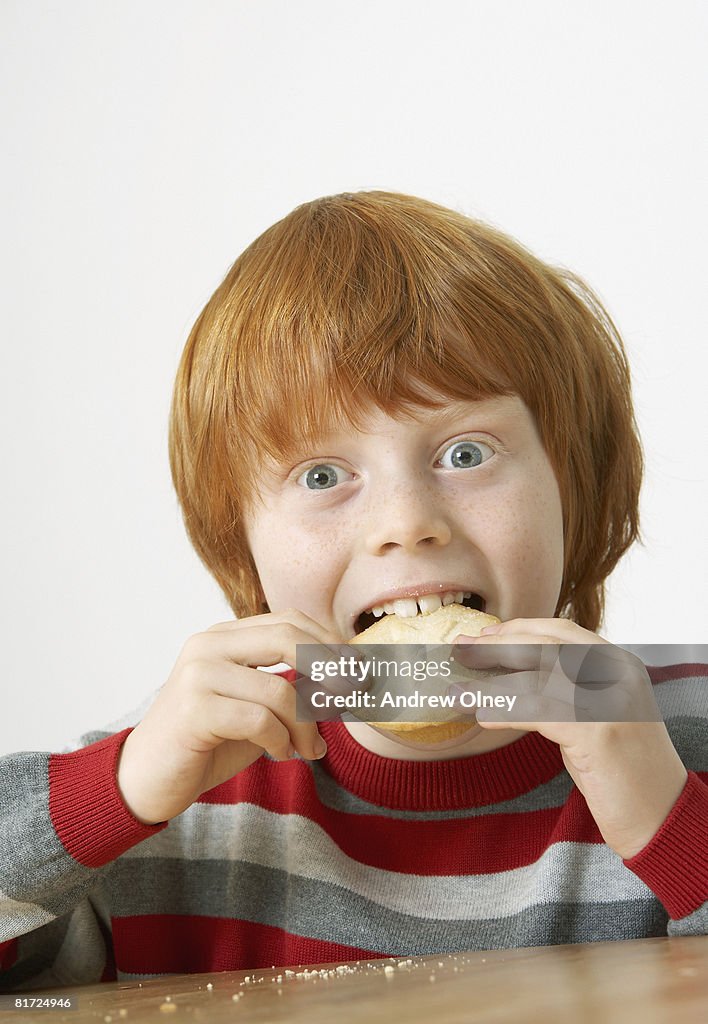 Young boy eating a mince pie