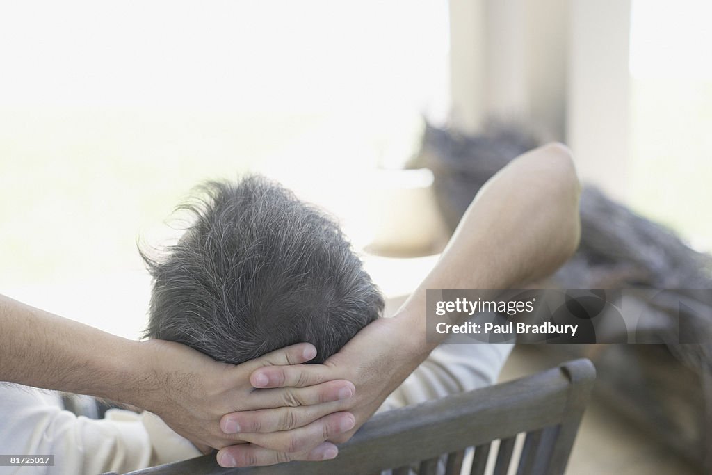 Man sitting outdoors in patio chair relaxing