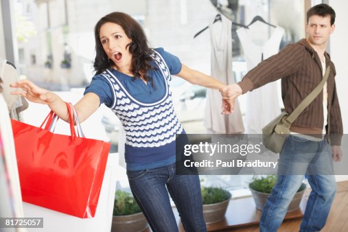 Person Pushing Garment Rack Man In Store Trying To Pull Woman Away From Clothes Rack High-Res Stock ...