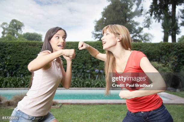 two women outdoors playfighting - rough housing stockfoto's en -beelden