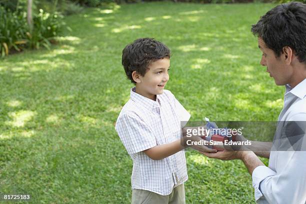man 屋外ギブ笑う少年ギフト - child giving gift ストックフォトと画像