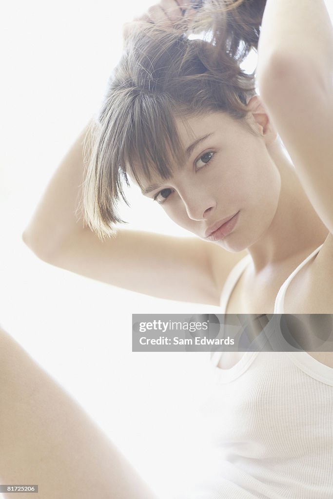 Woman indoors putting hair up