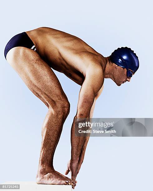 swimmer wearing cap and goggles on his mark - schwimmer startblock stock-fotos und bilder