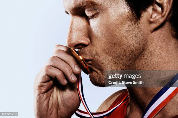 athete kissing gold medal - blank gold medal stock pictures, royalty-free photos & images