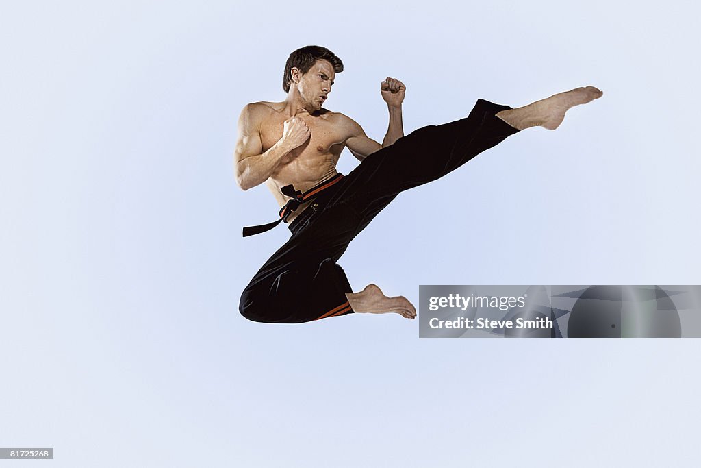 Man practicing martial arts and jumping in the air