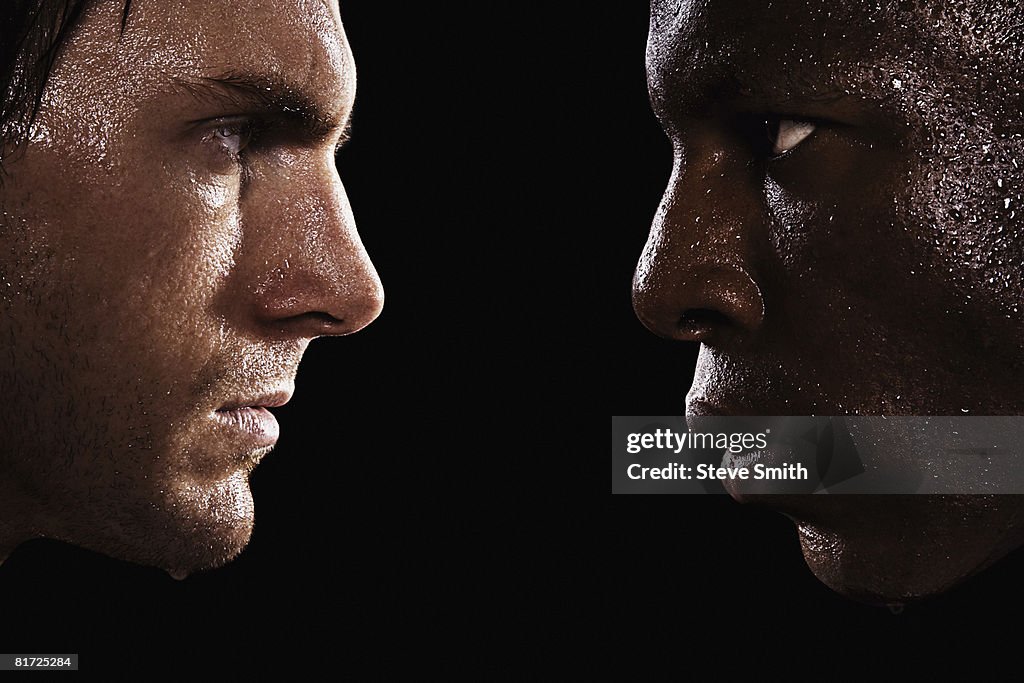 Two sweaty men looking at each other in intimidation