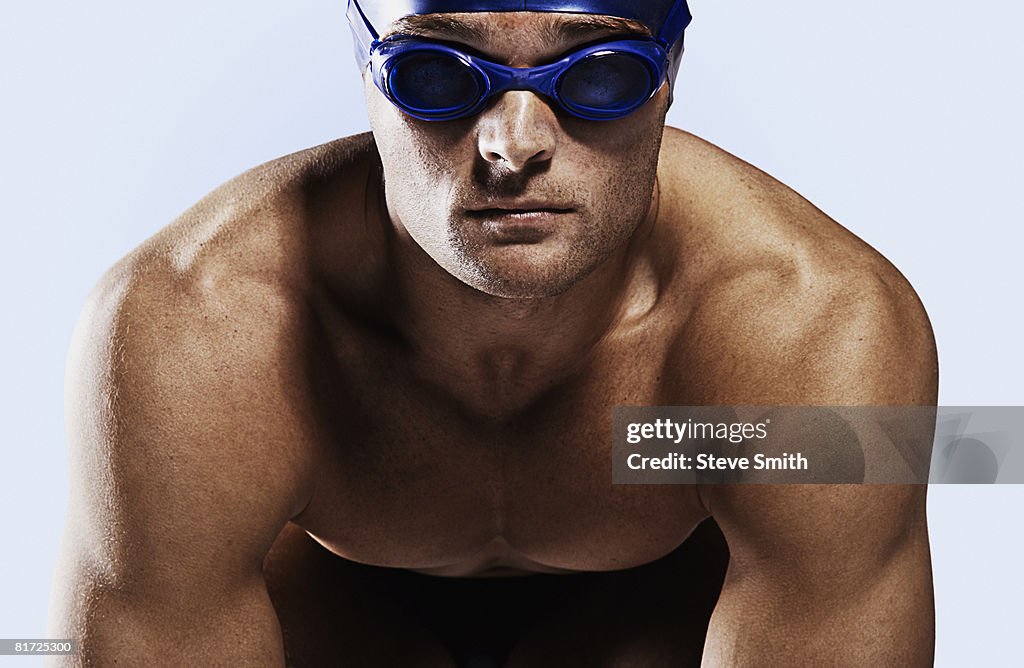 Swimmer wearing cap and goggles on his mark