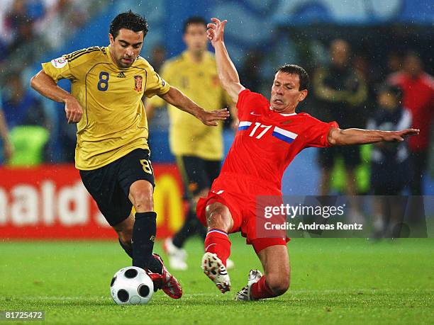 Xavi Hernandez of Spain is tackled by Konstantin Zyrianov of Russia during the UEFA EURO 2008 Semi Final match between Russia and Spain at Ernst...