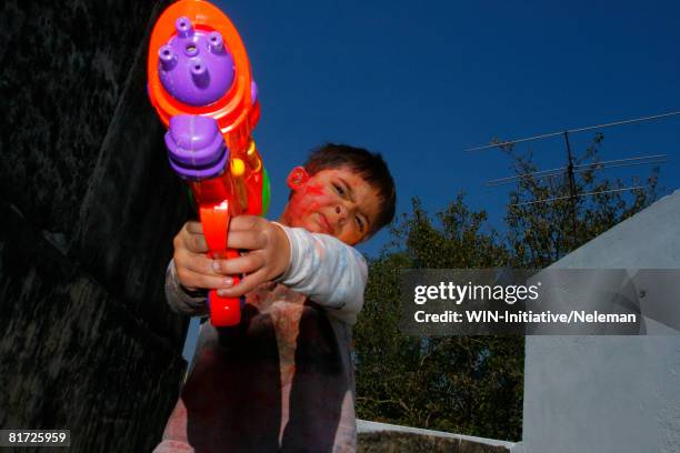 child with toy gun - holi festival and indian person stock pictures, royalty-free photos & images