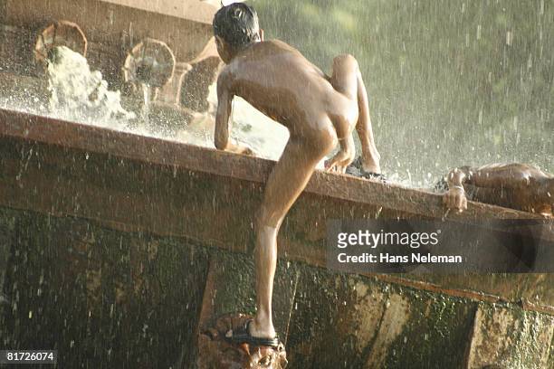 boy jumping out of a fountain, rear view - boys bare bum stock pictures, royalty-free photos & images