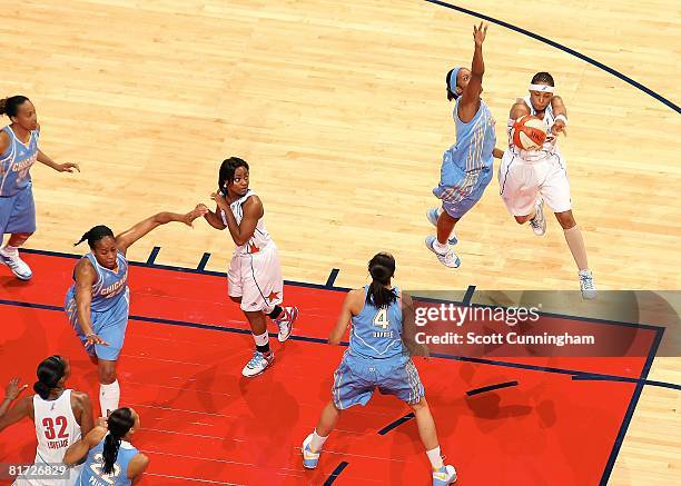 Betty Lennox of the Atlanta Dream passes the ball under pressure against Jia Perkins of the Chicago Sky watch the action from the bench during the...