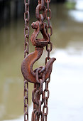 Antique rust of steel hook  carry steel chain and canal background.