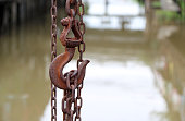Antique rust of steel hook  carry steel chain and canal background.