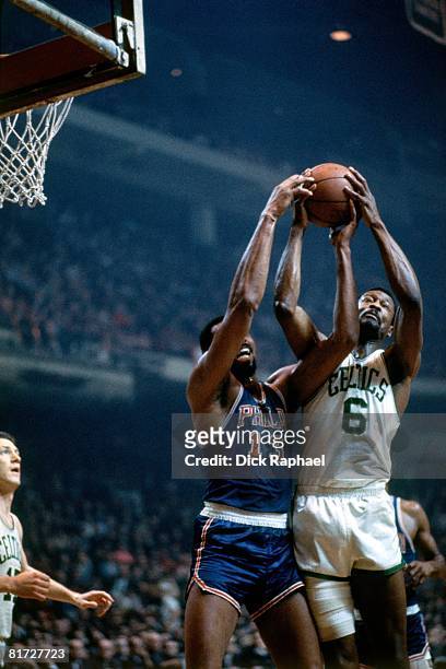 Bill Russell of the Boston Celtics battles for the rebound against Wilt Chamberlain of the Philadelphia 76ers during a game circa 1965 at the Boston...