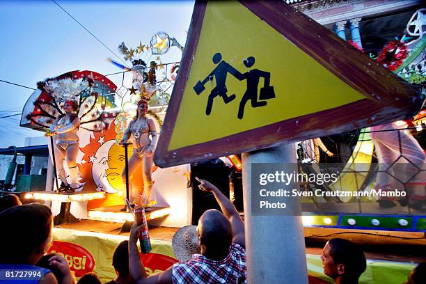 Cubans look at a dancers performing during the Camaguey carnival June 25, 2008 in Camaguey, Cuba. The first day celebration of the Camaguey St. John...