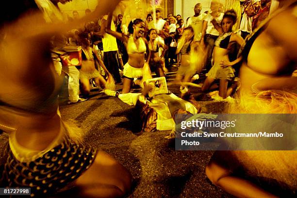 Cuban girls sway with their hips as they sit around a man who lies on the ground, as part of the opening ceremony during the Camaguey carnival June...