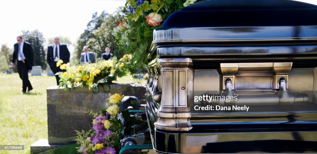 Funeral procession in cemetery.