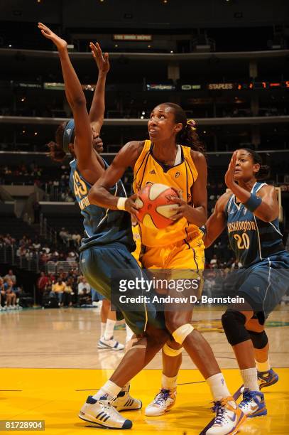 Lisa Leslie of the Los Angeles Sparks drives the ball to the basket as Alana Beard and Nakia Sanford of the Washington Mystics guard during the game...